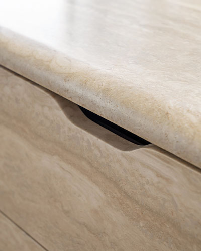 Dettaglio maniglia sagomata integrata nell’isola cucina Orizzonte Pianca in travertino, design minimale ed elegante.